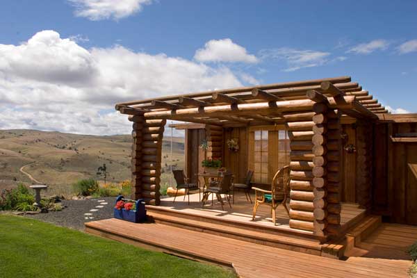 The Nearys built this log pergola as a refuge from Maupin's hot summer sun. It features a sunshade cloth overhead and Jeld-Wen French doors.