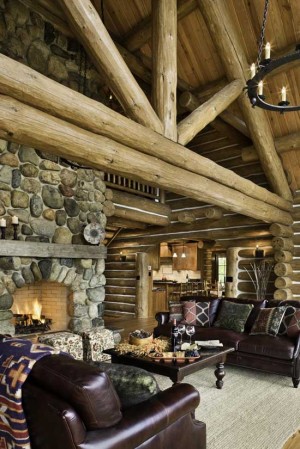 "When we started building, we thought we were only going to do the main floor and the upper floor," laughs Caroline Hickerson, whose 4,500-square-foot masterpiece boasts expanses of pine and natural stone in the great room and elsewhere. "And then we ended up finishing the lower level, too. I guess that often happens to people!" log beams log home great room stone fireplace