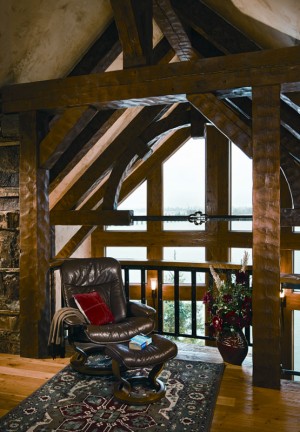 The loft is a cozy reading area and a place to appreciate the home's timber framing. timber beams log home loft reading nook
