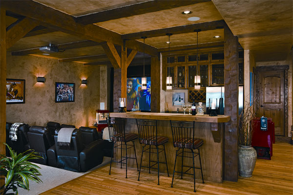 The couple loves to entertain and spends many evenings in the home's bar and theater area. log home home bar home theater timber beams