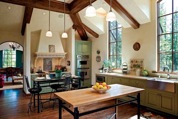 A rooster formed in metal tile struts above the commercial-style range in the cook's kitchen. Twin tables double the work space. Tall windows fill the room with light, even on Montana's gray days. Designer Carin Cross worked with the homeowners to formulate the perfect shade of green for the cabinets.